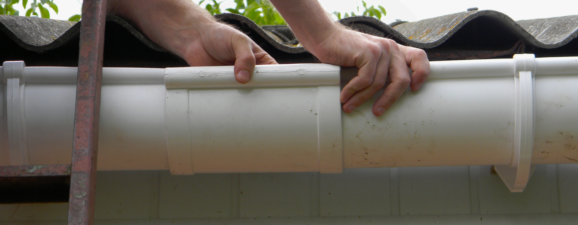 worker installing a white pbc gutter